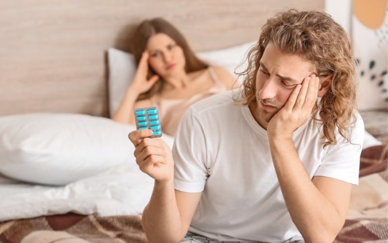 Man holding medicine in hand and deciding in between Sildenafil or Tadalafil.