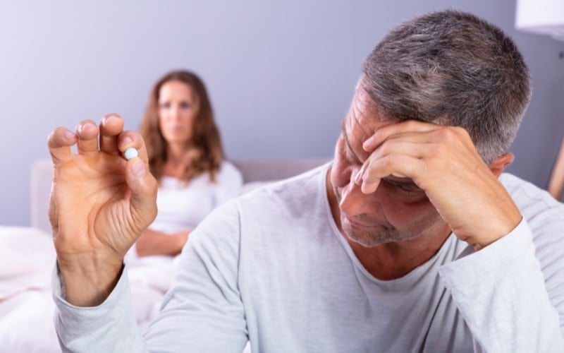 Man holding Tadalafil pill.
