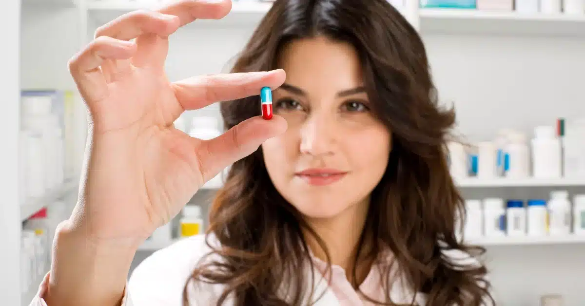 woman holding a pill
