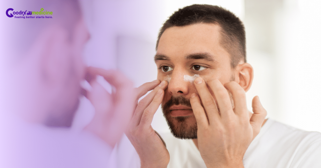 Man applying eye cream under his eyes