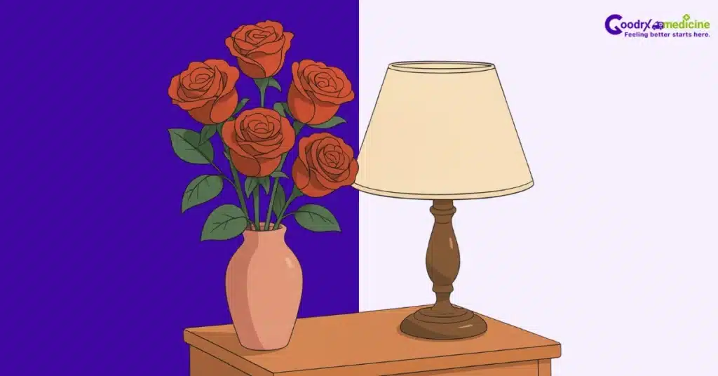 Roses in vase on lamp-lit bedside table