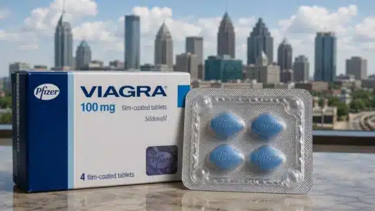 Viagra 100 mg box and tablets displayed against Atlanta skyline