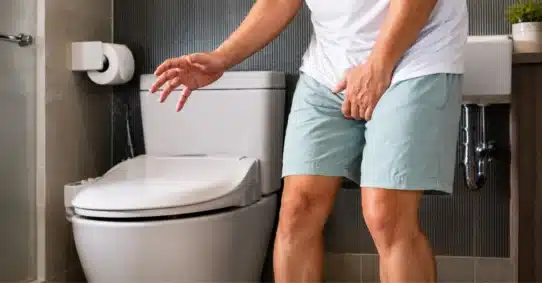 Man struggling to urinate while experiencing an erection